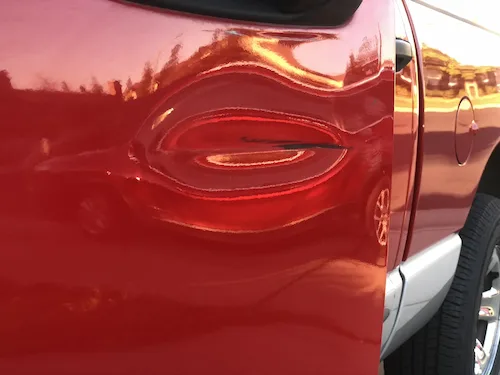 Dent before paintless dent repair on a Dodge Ram