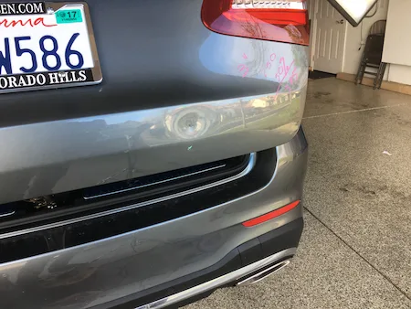 Dent before paintless dent repair on a Mercedes-Benz SUV